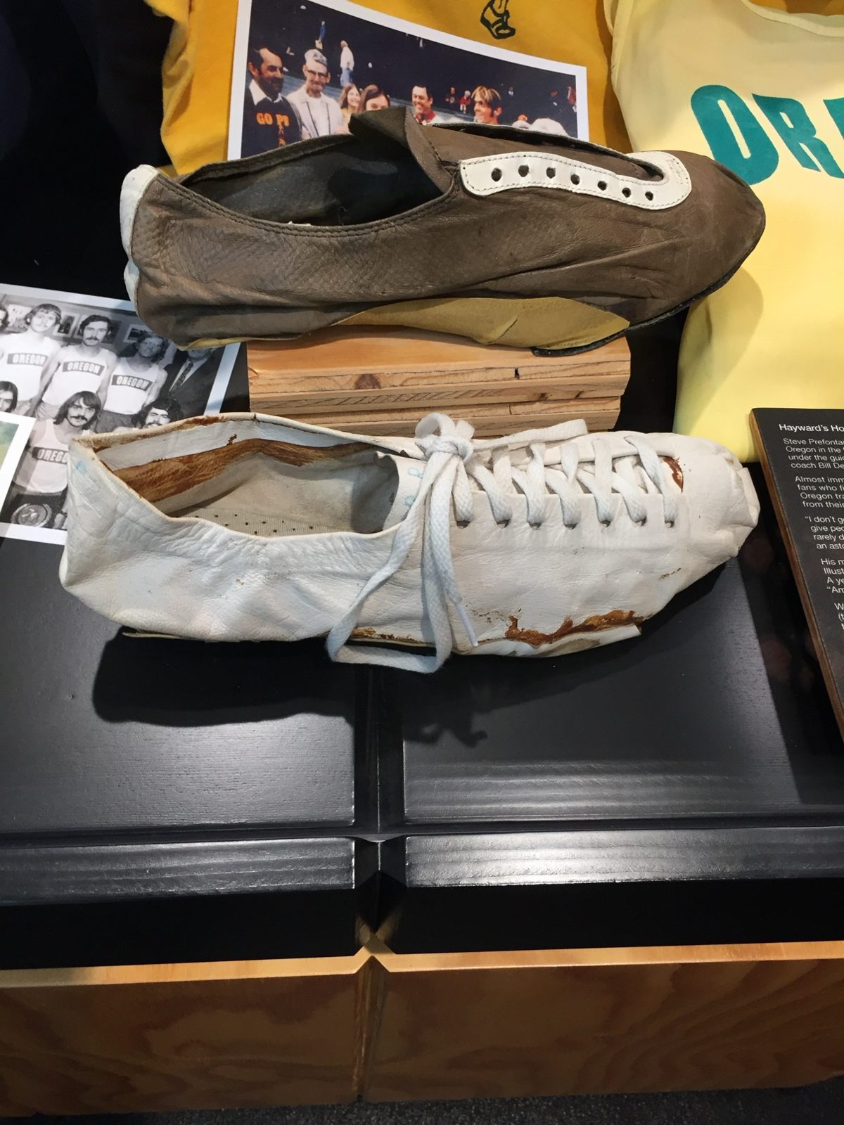 Pre's racing shoes on display at Nike Headquarters — a worn white leather racing shoe and a brown slipper-style shoe